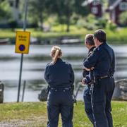 Poliser och polishundar undersöker det området där en kvinna hittats död. 
