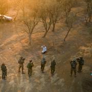 Israeliska soldater omringar en palestinsk man som sprang emot dem med en kniv på festivalplatsen där minst 260 israeler dödades av Hamas.