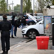 Poliser vid gärningsmannens bil.