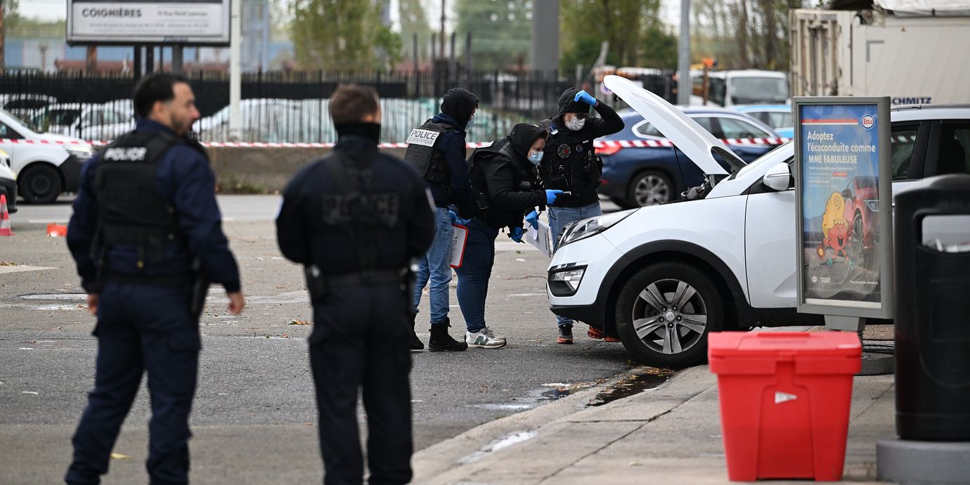 Poliser vid gärningsmannens bil.