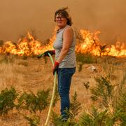 Kvinna försöker släcka skogsbrand i nordvästra Spanien.