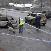 Polisens hundförare undersöker en av bilarna som var inblandad i skottlossning på Bällstavägen i stadsdelen Mariehäll, nära Bromma flygplats. Foto: Jessica Gow / TT / kod 10070