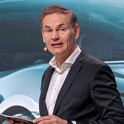 Till vänster: Anställda deltar i en facklig protest utanför Volkswagens huvudkontor i december 2024. Till höger: Volkswagens koncernchef Oliver Blume på en presskonferens i Berlin 2023.