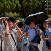 Turister i Barcelona försöker ta skydd för solen.