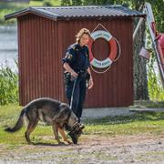 Polis söker vid platsen där kvinnan hittades mördad.