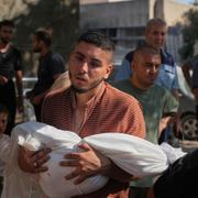 En man bär ett barn som dödades i ett israeliskt luftangrepp i staden Gaza, 30 juni 2025. 