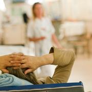 En patient ligger i en säng i en korridor på akuten på Södersjukhuset.