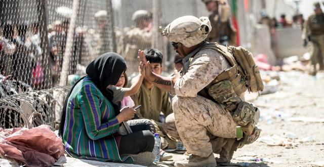 Amerikansk soldat och afghaner vid flygplatsen i Kabul, 25 augusti.  Sgt. Samuel Ruiz / TT NYHETSBYRÅN