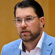 Till vänster: Migrationsverkets lokaler i Malmö. Till höger: Sverigedemokraternas partiledare Jimmie Åkesson under partiledardebatt i riksdagen den 10 juni i år.