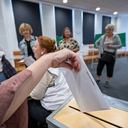 Till vänster syns förtidsröstande Karlshamnsbor under fredagen. Till höger syns en av reaktorerna vid kärnkraftverket Forsmark.