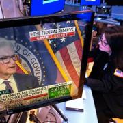 Tradern Phyllis Arena Woods, med Fed-chefen Jerome Powell på tv-skärmen. Arkivbild.