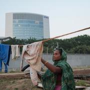 En kvinna hänger tvätt framför Adanis kontor i Ahmedabad. 