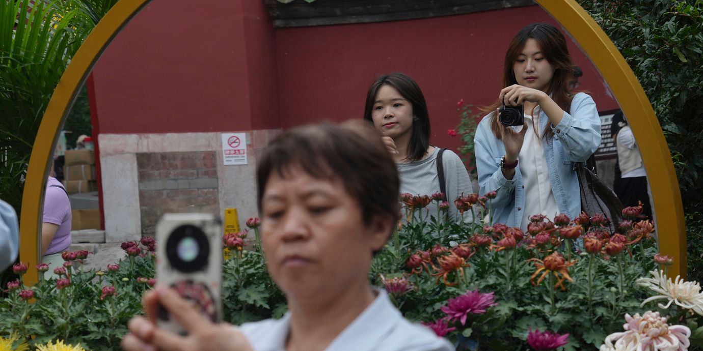 Människor tar kort i en park i Peking, illustrationsbild (26 september).