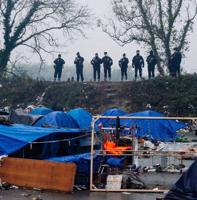 Police forces watch the migrants makeshift camp in Grande-Synthe, Northern France, Tuesday, Nov. 16, 2021. French police were evacuating migrants from a makeshift camp near Dunkirk, in northern France, where at least 1,500 people gathered in hopes of making it across the English Channel to Britain. Migrants, including some families with young children, could be seen packing their few belongings as police were encircling the camp, on the site of a former industrial complex in Grande-Synthe, east of Dunkirk. Louis Witter / TT NYHETSBYRÅN