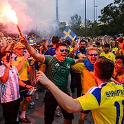 Svenska fans firar utanför arenan inför match.