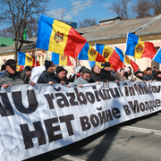 Proryska demonstranter i Moldavien. Till höger går en man förbi valaffischer för Ilan Shor. Arkivbilder. 