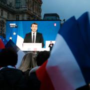 Emmanuel Macrons supportrar följer segertalet på en storbildsskärm utanför Louvren i Paris.