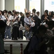 Folk väntar på taxibilar i regnet i Nagoya. Arkivbild från 8 september.
