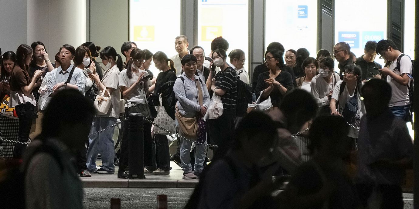 Folk väntar på taxibilar i regnet i Nagoya. Arkivbild från 8 september.