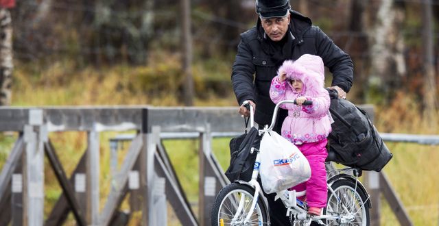 Arkivbild, 2015, en liten flicka får hjälp på cykel över gränsen. NTB SCANPIX / TT NYHETSBYRÅN