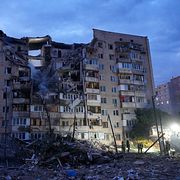 Räddningsarbetare på plats vid en attackerad byggnad i Kyiv.