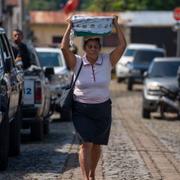 Kvinna omgiven av poliser och soldater i Comasagua, El Salvador, i oktober. Det är varken María eller Hilda på bilden. 