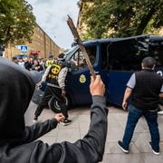 Salwan Momika förs bort i en polisbil efter en allmän sammankomst på Värnhemstorget i Malmö på söndagen. Koranbränningen väckte starka protester.