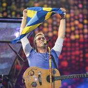 Chris Martin håller upp en Sverige-flagga under konserten på Ullevi. 