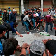 Irakiska demonstranter slår sönder en bit av den cementmur som skulle hålla dig borta från Ahrar-bron i centrala Bagdad.