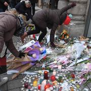 Människor lämnar blommor för att hedra offren för dådet