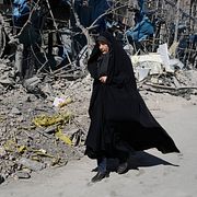 Kvinna går förbi bombad byggnad i Teheran, 3 mars.