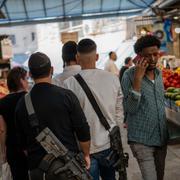 Israeliska soldater som inte är i tjänst går med sina vapen på en marknad i Jerusalem.