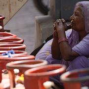 En kvinna väntar på att få köpa flytande naturgas i Ahmedabad i Indien.