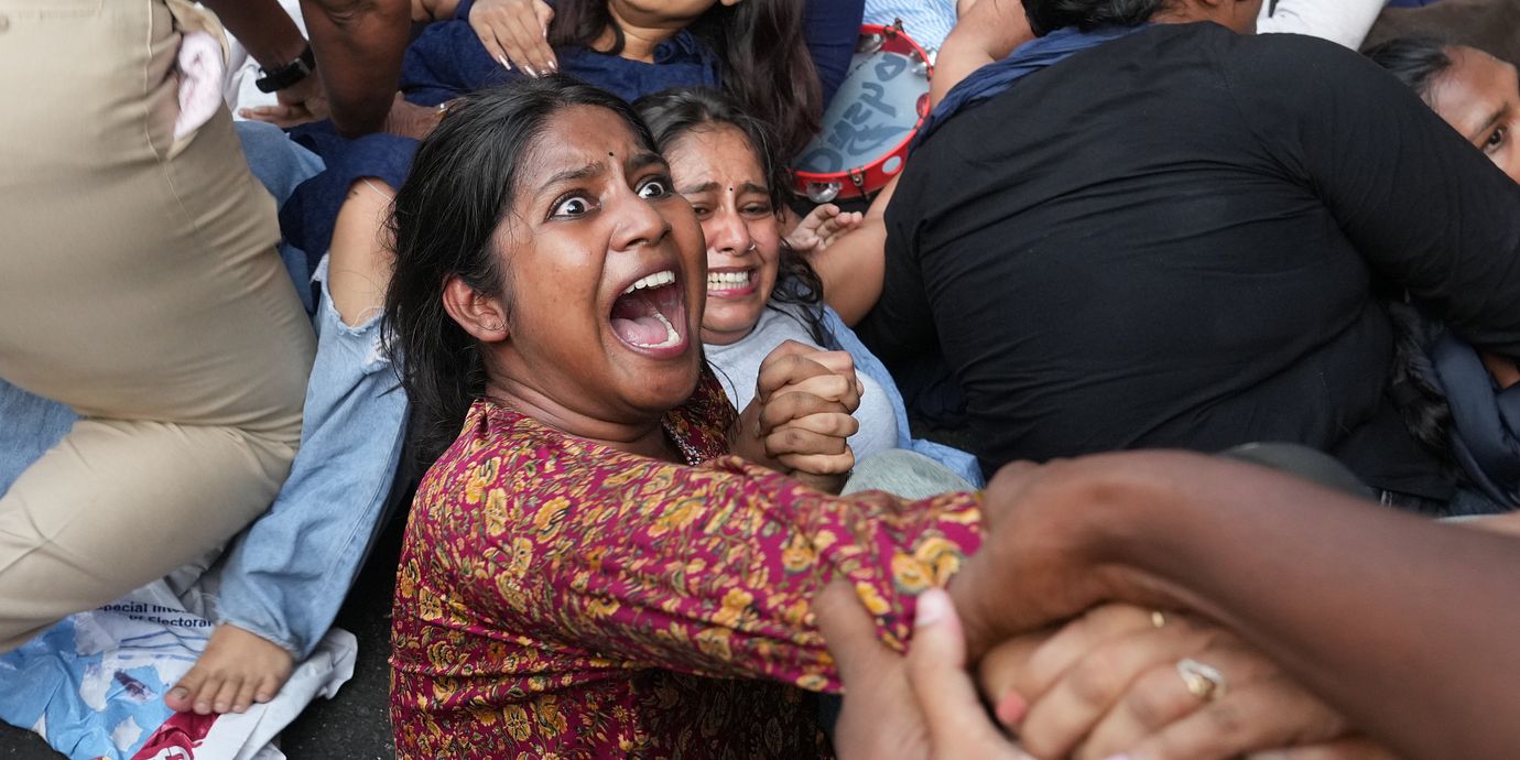 En kvinna grips under helgens protester i New Delhi.