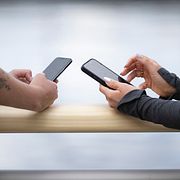 Illustrationsbild: Två kvinnor surfar och scrollar sociala medier på sina telefoner.