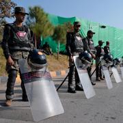 Paramilitära soldater blockerar en väg utanför Islamabad på söndagen. Regeringen har stängt ned stora delar av staden och infört utegångsförbud inför protesterna.