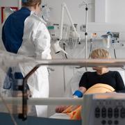 En sjuksköterska vid en sjuksäng på en canceravdelning på Karolinska universitetssjukhuset i Solna. Genrebild. 