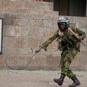 En kenyansk polis använder en piska mot en demonstrant i Nairobi den 25 juni.  