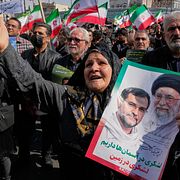 Kvinna i Teheran håller upp porträtt på en av ledarna för Irans revolutionsgarde, samt ayatollah Ali Khamenei som dödades tidigt i kriget. Arkivbild från 1 april.