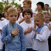 Drygt 20 000 ukrainska barn ska ha förts till Ryssland eller ryskkontrollerat område sedan 2014. På bilden syns barn och föräldrar som sjunger Ukrainas nationalsång under skolstartsfiranden i Kyjiv, den 1 september 2026.
