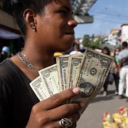 Ung man i Venezuela visar upp sina dollarsedlar 2021.