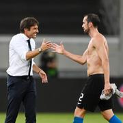 Inters huvudtränare Antonio Conte ler mot spelaren Diego Godin. 