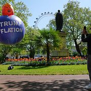 En man tar en bild av en ballong med texten ”Trumpflation” i Storbritannien i april.