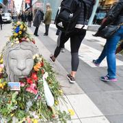 Ett betonglejon täckt av blommor på Drottninggatan efter terrorattacken.