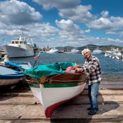 En äldre man pysslar om sin båt på den italienska ön Sardinien – en av världens fem blå zoner.