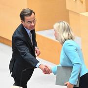 Statsminister Ulf Kristersson (M) och Socialdemokraternas partiledare Magdalena Andersson (S) skakar hand under partiledardebatten i riksdagens kammare under onsdagen.