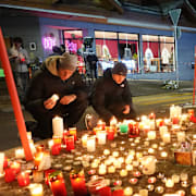 Människor tänder ljus i närheten av olycksplatsen.
