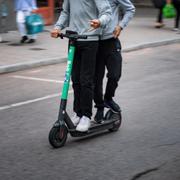 Två personer på elsparkcykel.