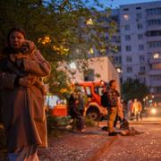 En kvinna utanför en byggnad som skadades i nattens attack