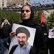 Iransk kvinna med porträtt på Mojtaba Khamenei.